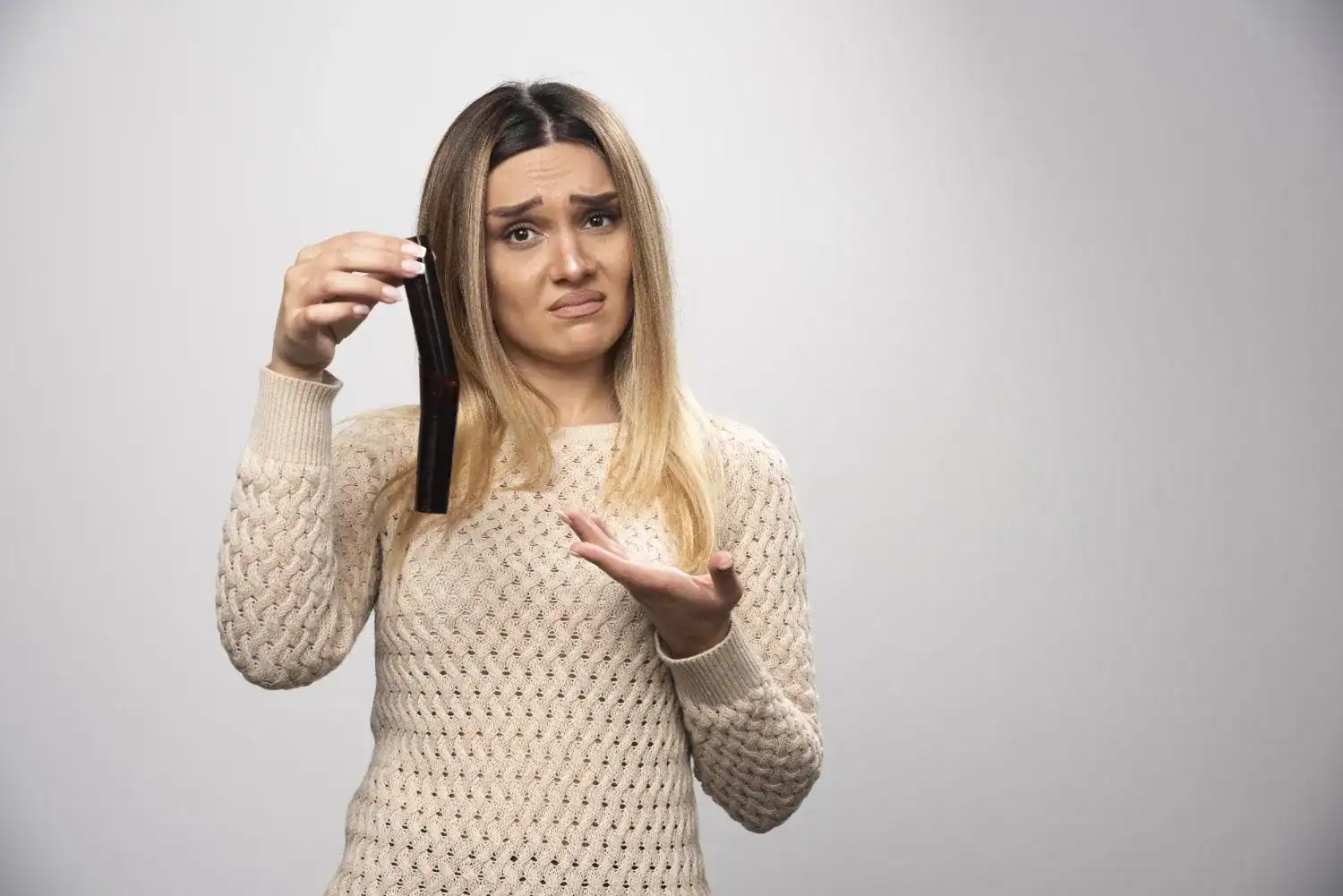 Worried woman holding a wig hair extension, Minnesota hair care concerns.