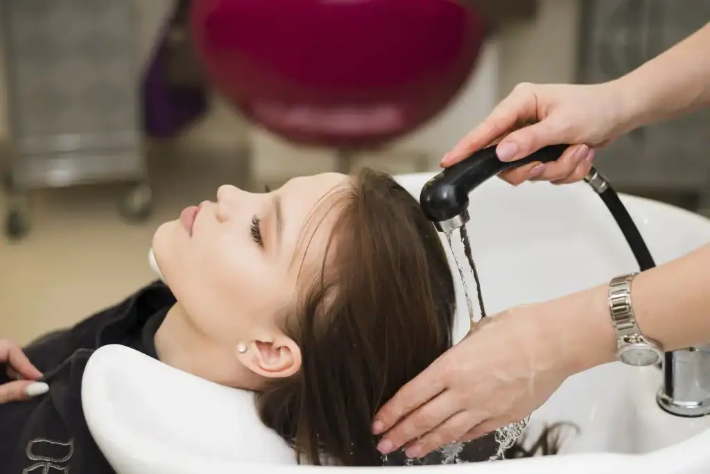 Woman getting her hair washed at Wigs by Opulence salon in Minnesota.