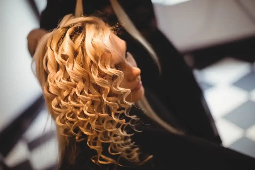 Blonde curly wig styled at Wigs by Opulence salon MN.