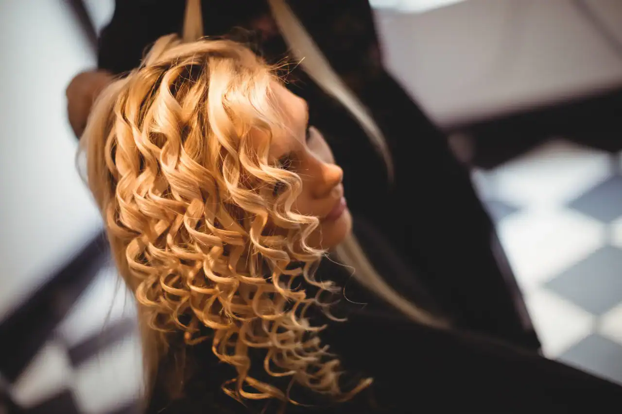 Blonde curly wig styled at Wigs by Opulence salon MN.